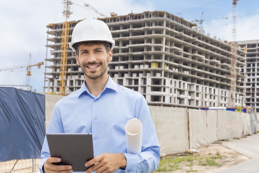 Male construction leader wearing a hard hat on a building site